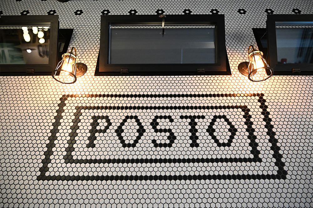 This is a photo of the Posto Italian logo on a wall in tile.